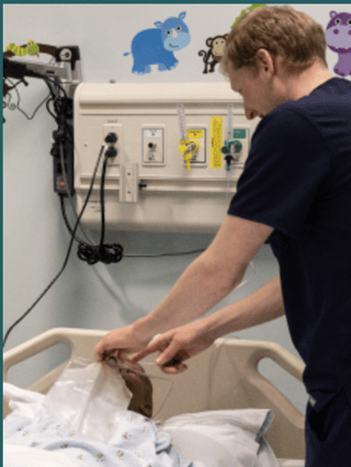 a student placing an air mask on a manikin