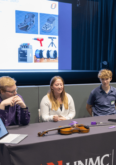 three students presenting 3D printed device